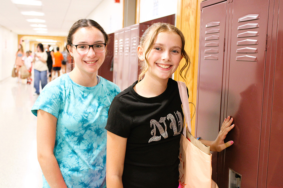 student poses with family member next to open locker.