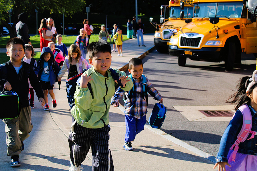 Jamesville Elementary students walk towards school off buses excited. 