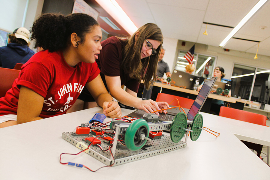 two students working on robotics project while using Chromebook. 