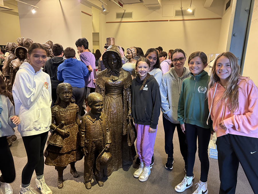 Students pose with statues during field trip.