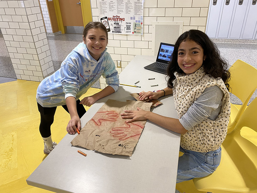 Students smile for camera while working on a project.