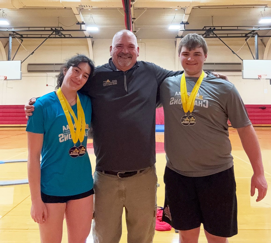 Kevin Vigneault and Skylar Vaught pose for photo with coach after winning Section 3 Shot Put and. Weight Throw